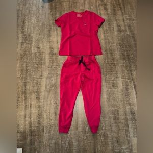 Hot pink figs scrubs set with purple tie on pants.